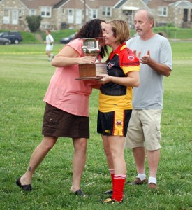 Mairead Farrell Team Captain Ciara Moore gets a kiss on the cheek from Ann Marie Cawley, sister of the late Sean P. Cawley, after whom the divisional championship cup is named. 