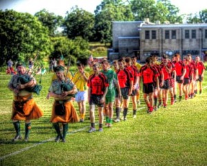 The Young Irelands (in red) and the Kevin Barrys (in yellow) are piped onto Cardinal Dougherty Field for Sunday's championship. Photo by Eileen McElroy. 