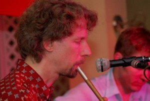 Tim Britton, taking a turn on the tin whistle. Brian Miller accompanies on guitar.