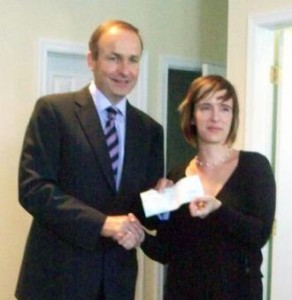 Ireland's Minister of Foreign Affairs Micheal Martin presents a check to Immigration Center Executive Director Siobhan Lyons.