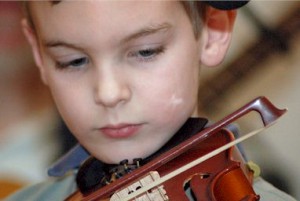 Patrick Glennan, 8, concentrates intently on his fiddle playing.