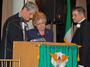 President Russell W. Wylie presents the Presidential Medal posthumously for Thomas O. Peterman, to Susan Peterman, his widow. At right is Todd R. Peterman, his son.