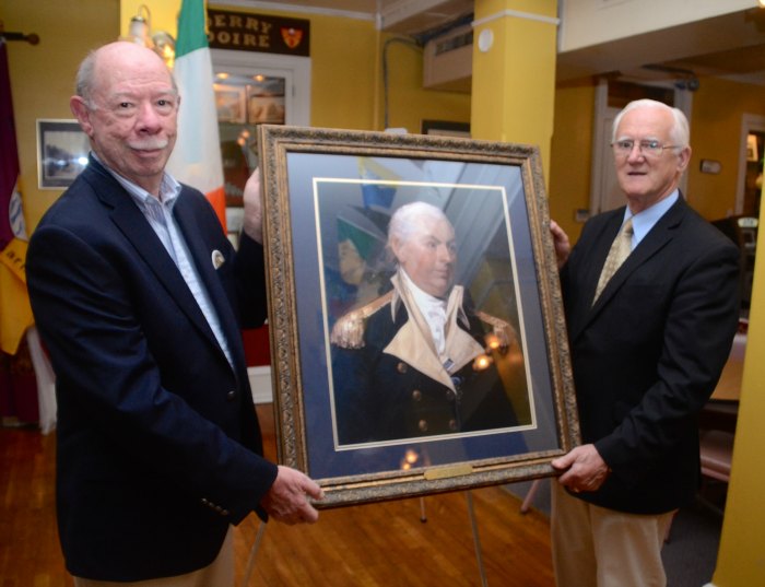 The Irish Center's Frank Hollingsworth and Sean McMenamin accept the Barry portrait.